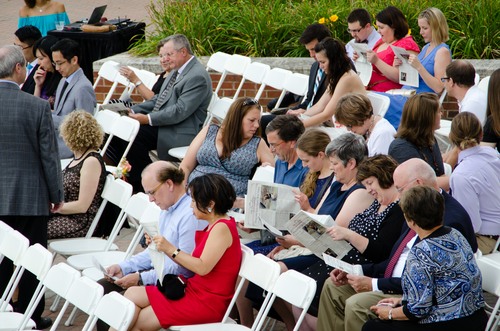guests enjoying wedding program newspapers